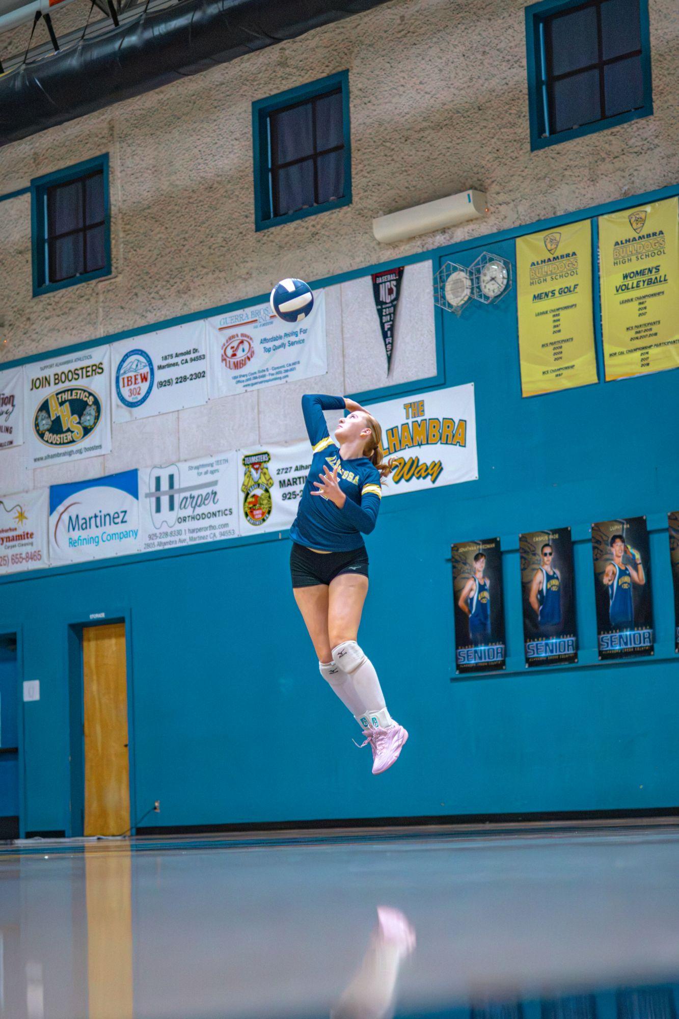 Alhambra server leaps under a high ball toss