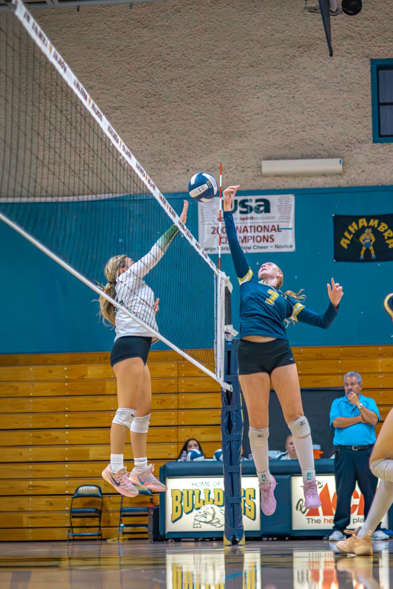 Alhambra #7 and an opposing player leap at the net