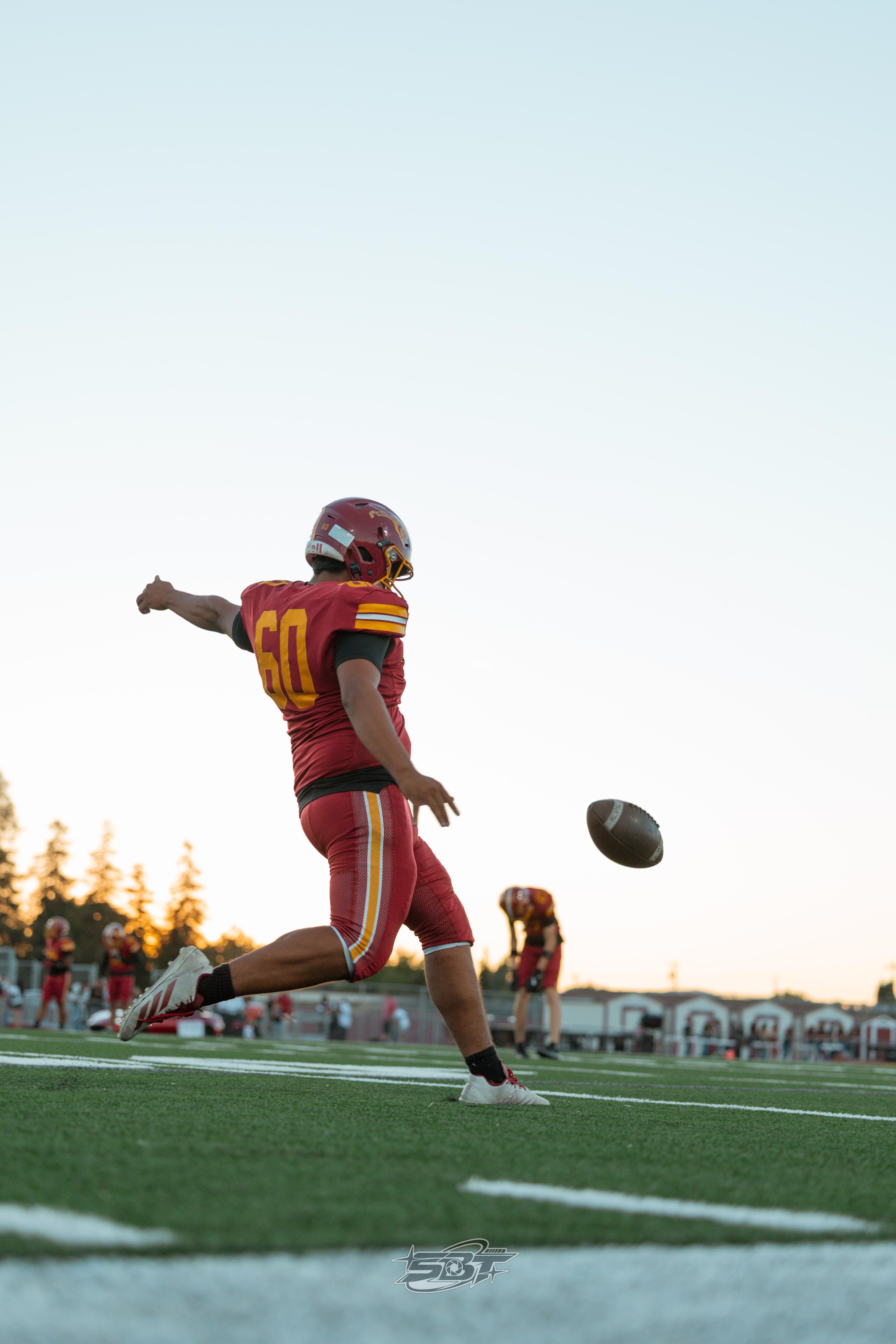 Liberty player kicking at sunset