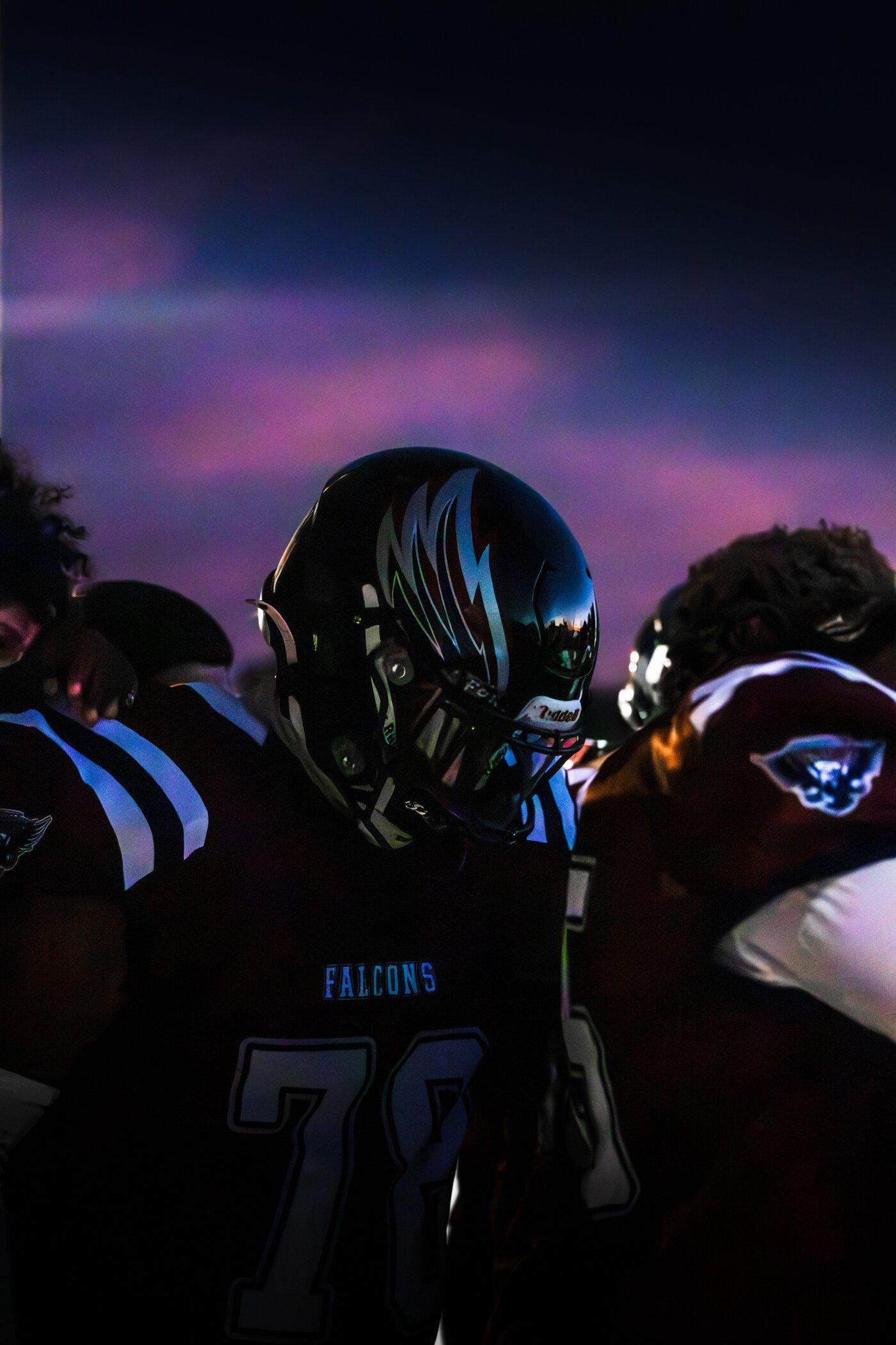 Freedom Falcons huddled under a dramatic evening sky