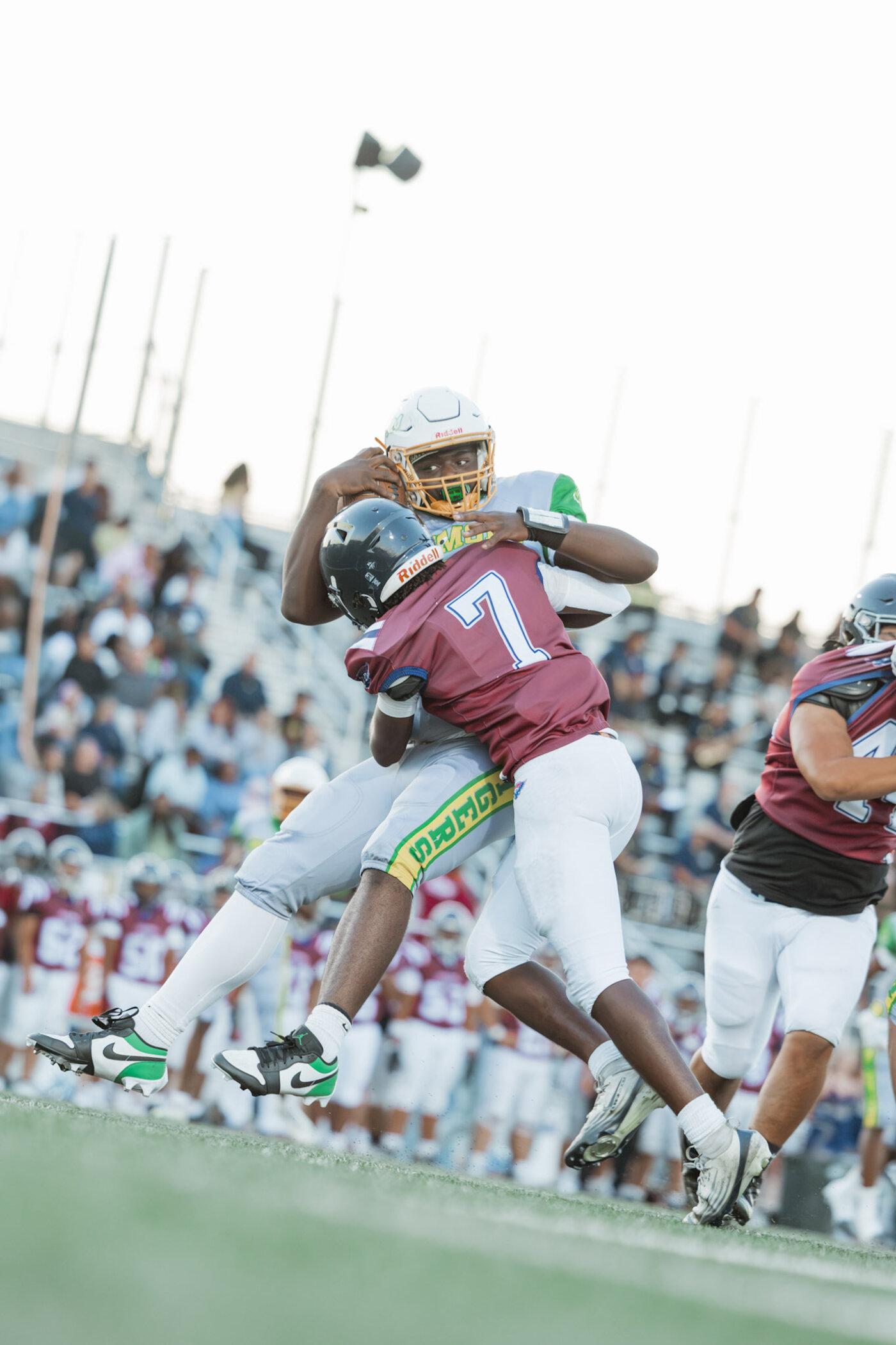Freedom Falcons ball carrier wrapped up by a Fremont defender