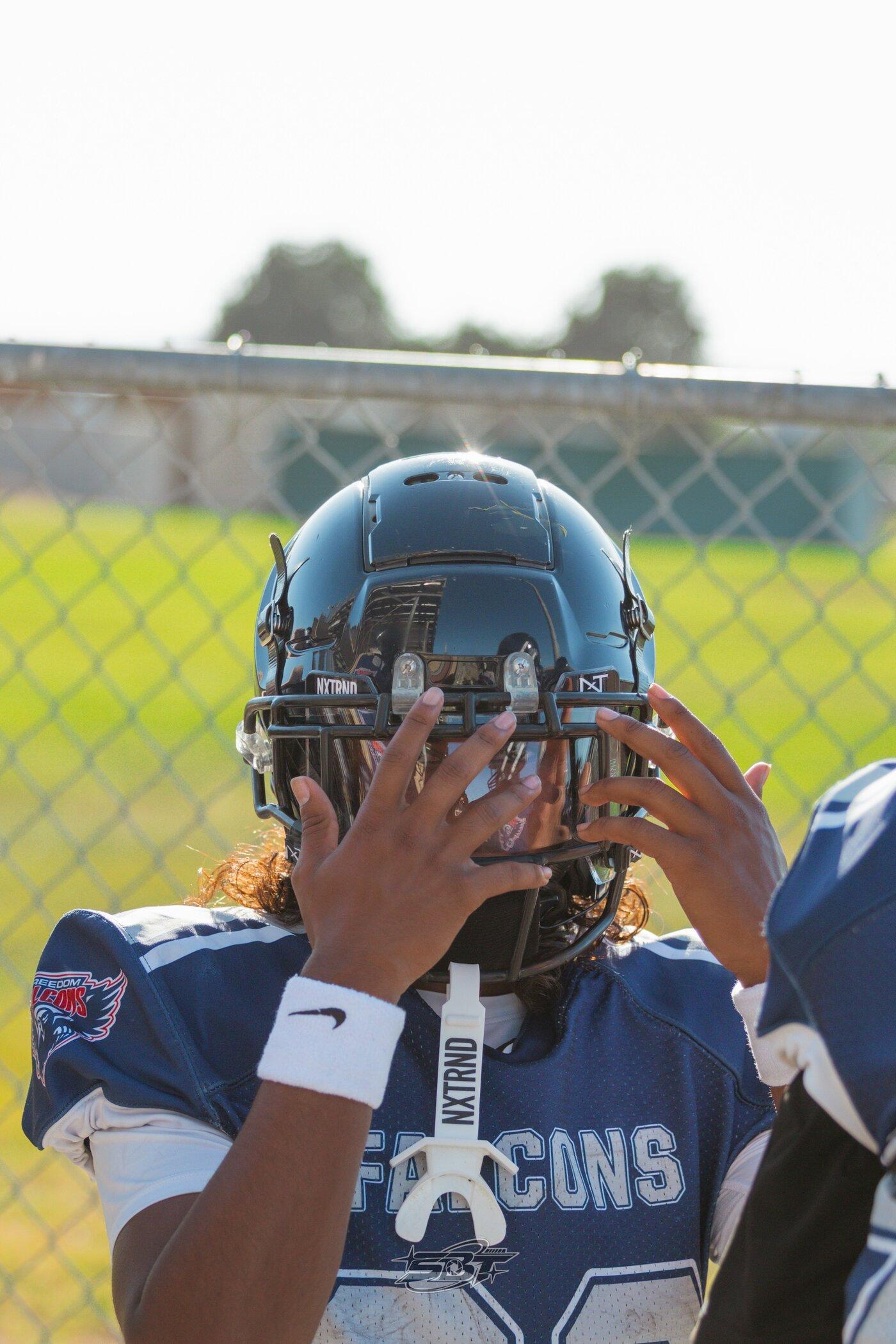 Freedom JV player raising his helmet